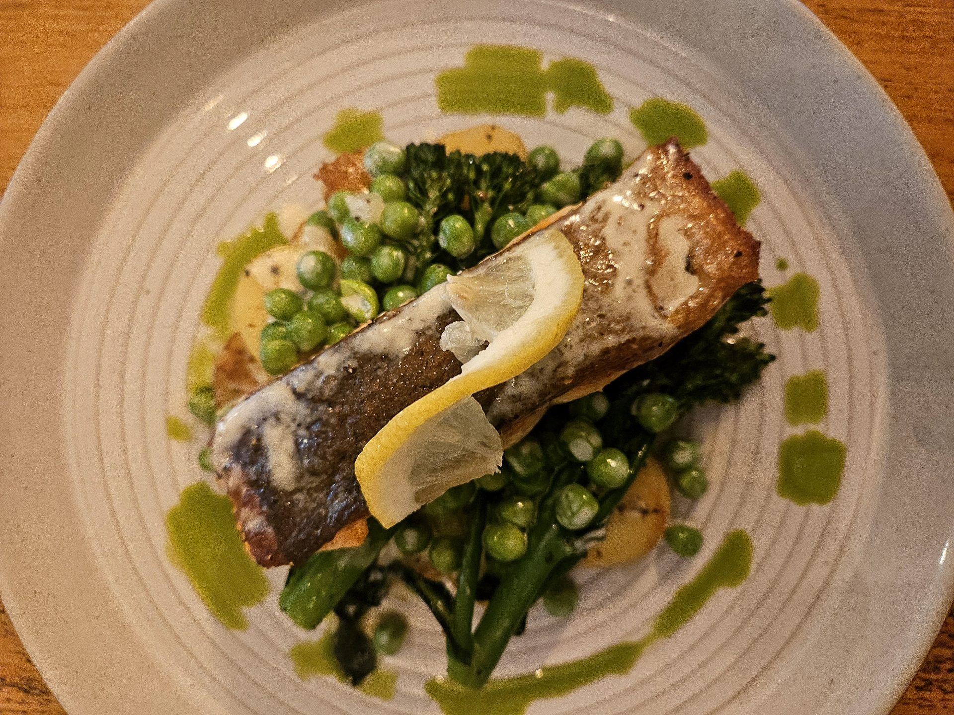 A waiter serves a fresh salad and hors d'oeuvres in a cozy restaurant setting.